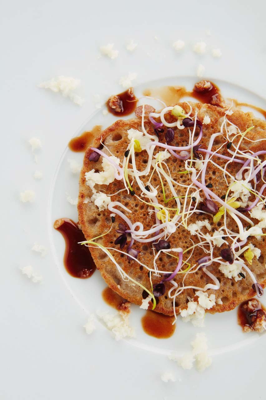 Pancakes made from oats and buckwheat with sprout mix and pear syrup.