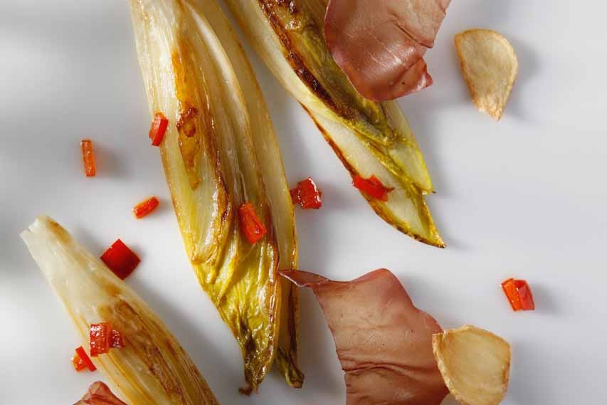 Plancha of Belgian Endive with Bresaola, Garlic Chips, and Bell Pepper Strips