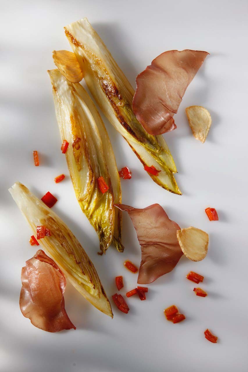 Plancha of Belgian Endive with Bresaola, Garlic Chips, and Bell Pepper Strips