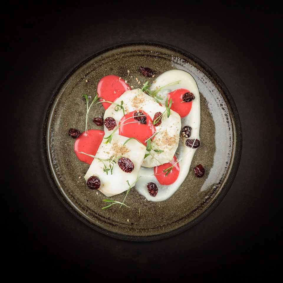 Celeriac on an open fire with gomasio and rosemary. Vinaigrette of pink grapefruit and cranberries. Dried cranberries and Ghoa cress.